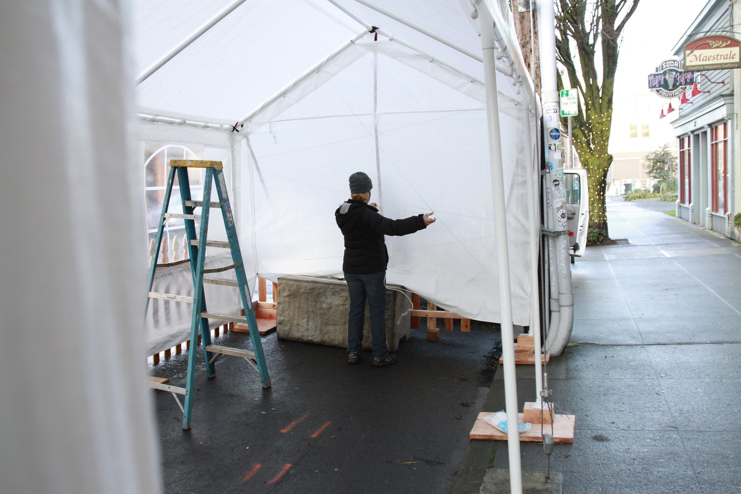 Kris Nelson, owner of several Port Townsend bars and restaurants, erects an outdoor dining shelter in front of Sirens on Water Street.