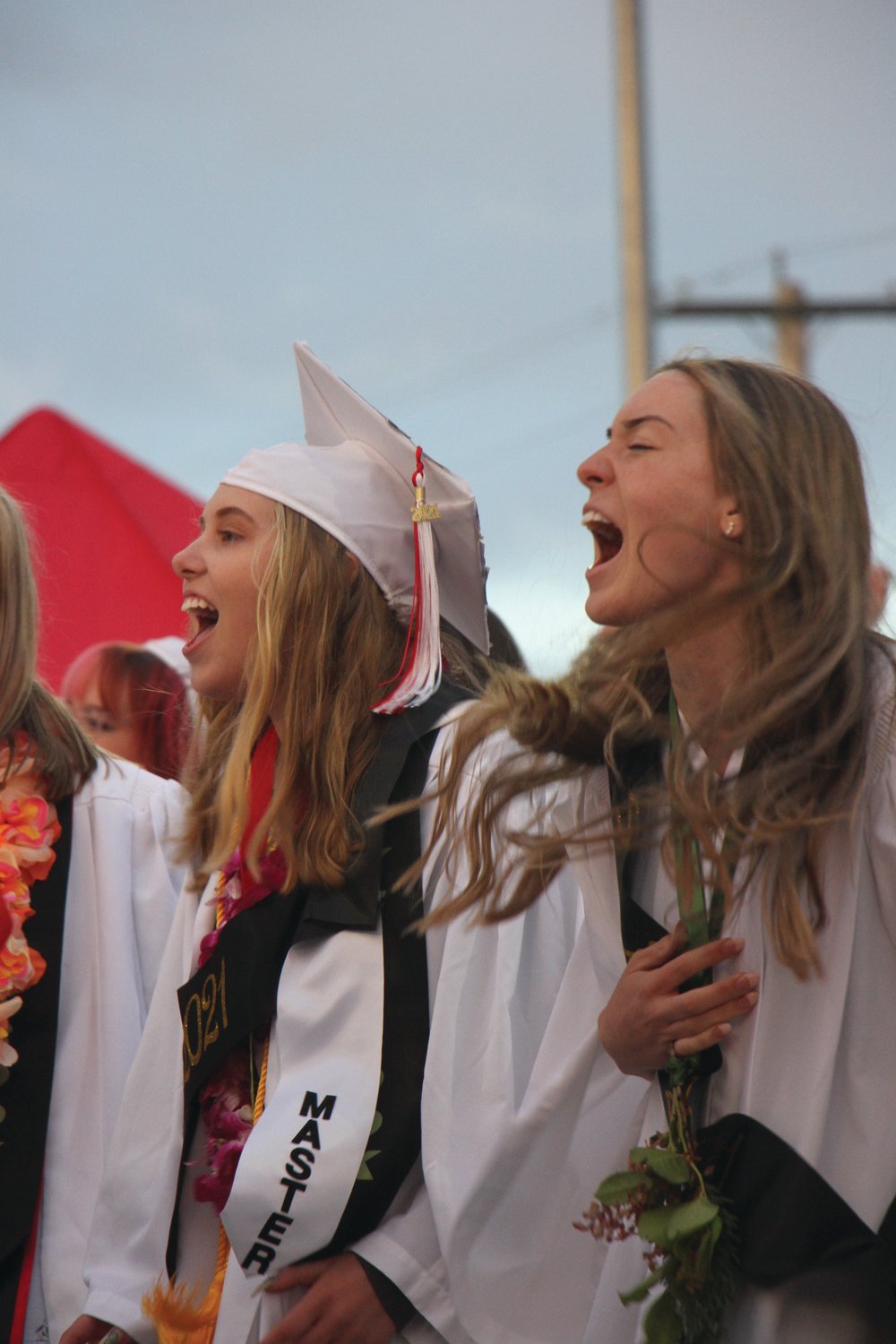 Graduates sing the alma mater with enthusiasm at the close of the ceremony.