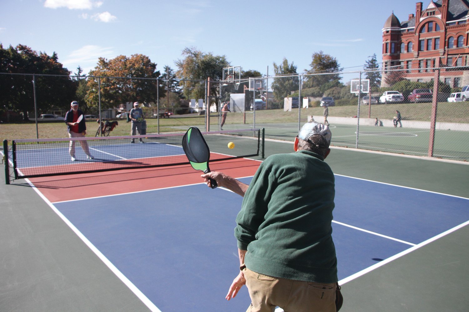 Monday afternoon at the pickleball court in Courthouse Park, Tom Young smacks a pickleball over the net.