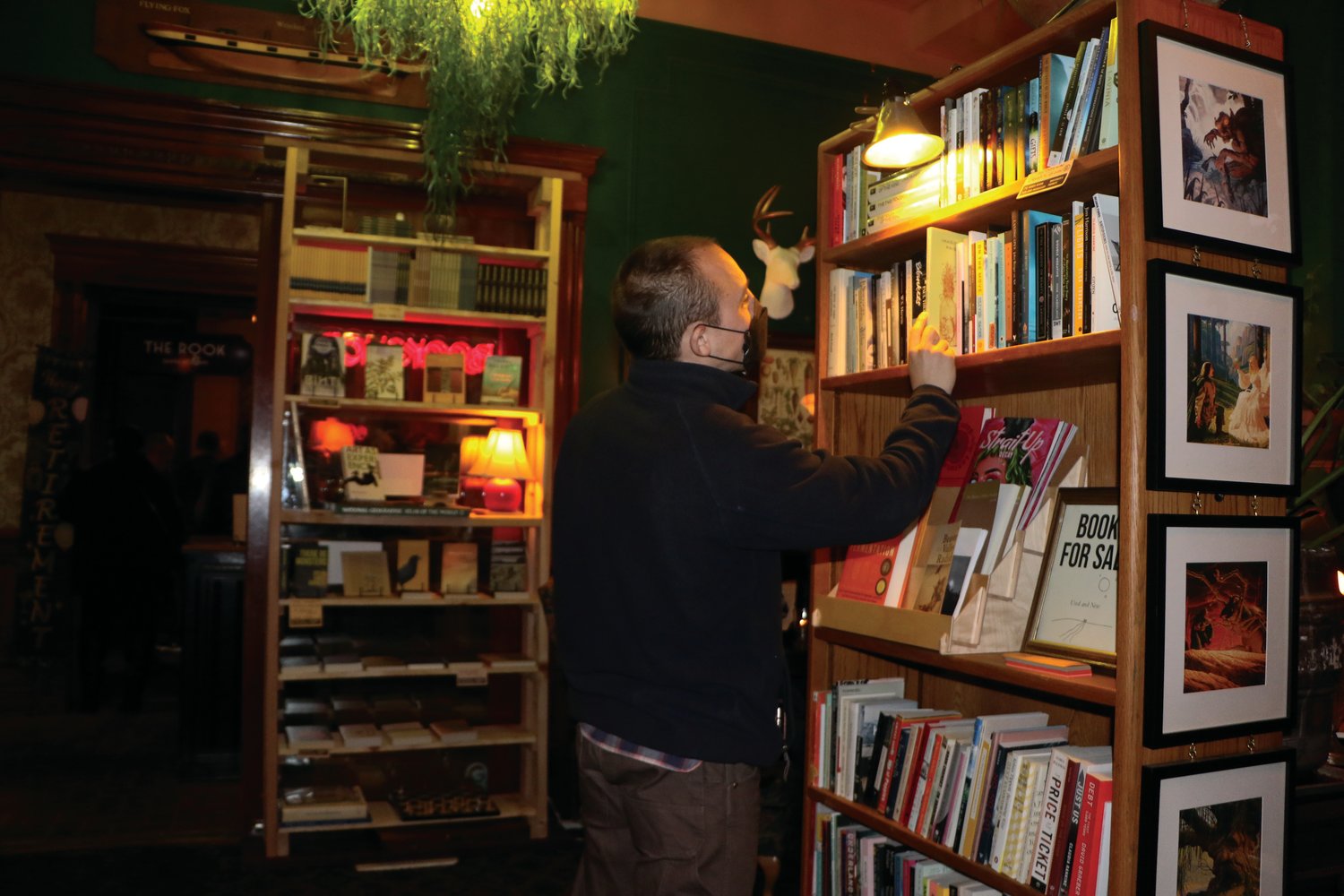 Owner and publisher, Conner Bouchard-Roberts, adjusts shelves in his new bookshop.