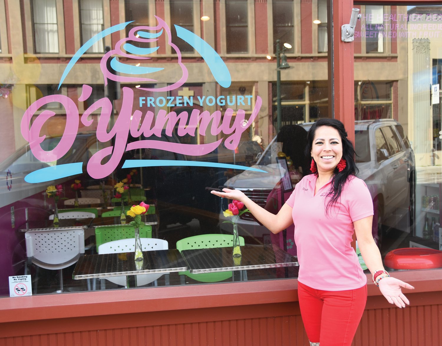 Rosie Olson smiles at the storefront for O’Yummy Frozen Yogurt on Taylor Street.