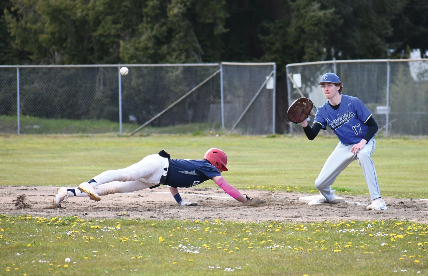 Rivals first baseman Owen Thornton prepares to catch the ball in an attempt to tag out a Cougar runner in the first game against Cascade Christian.