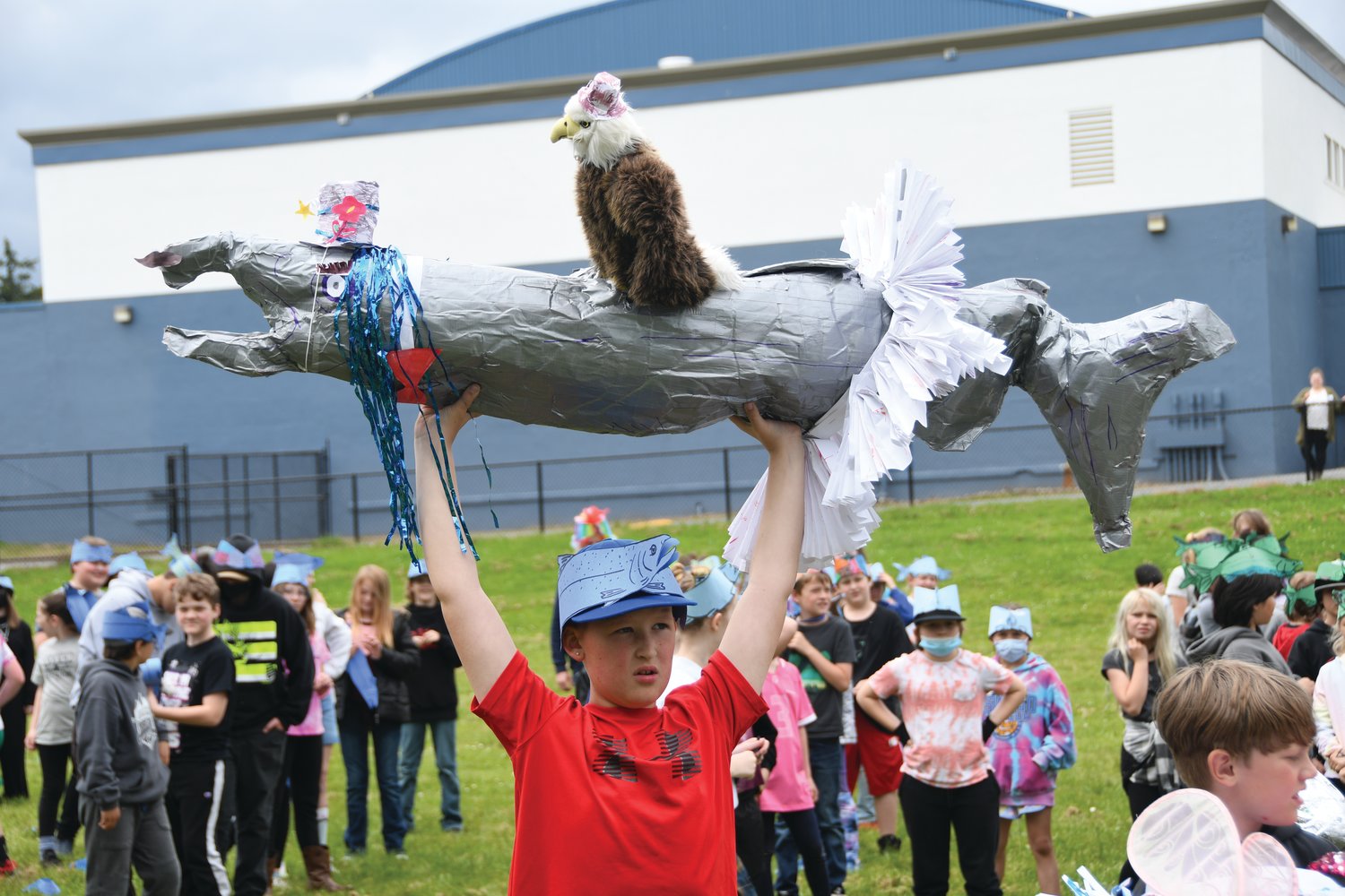 Fifth-grader Brayden Tuttle holds up his team’s salmon avatar, decorated with an eagle and a tutu.