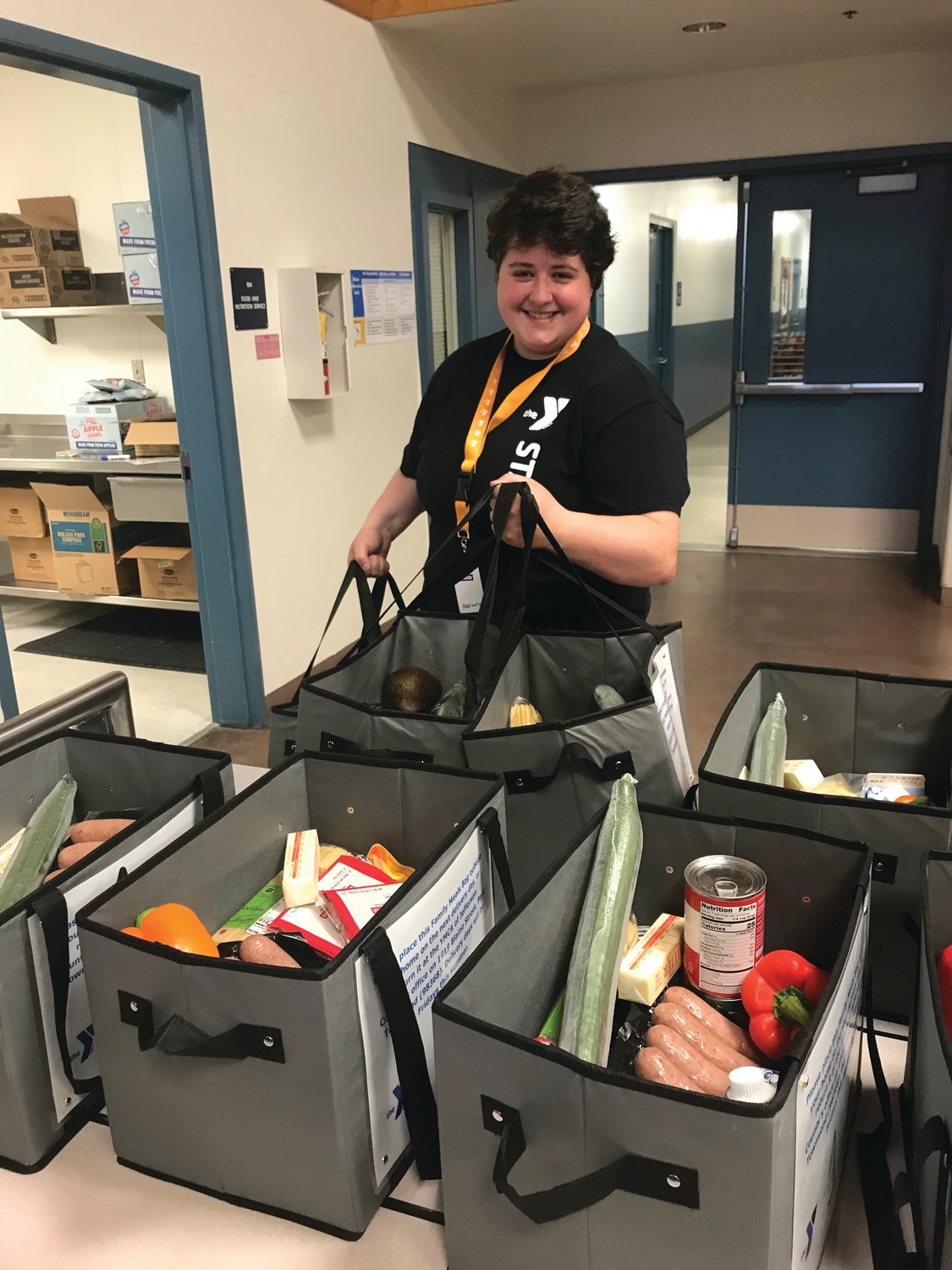 Sarah Henry of the YMCA packs bags of food for children and teens in Jefferson County. The YMCA supplies meals for the youth of Jefferson County during summer months when kids are out of classrooms.