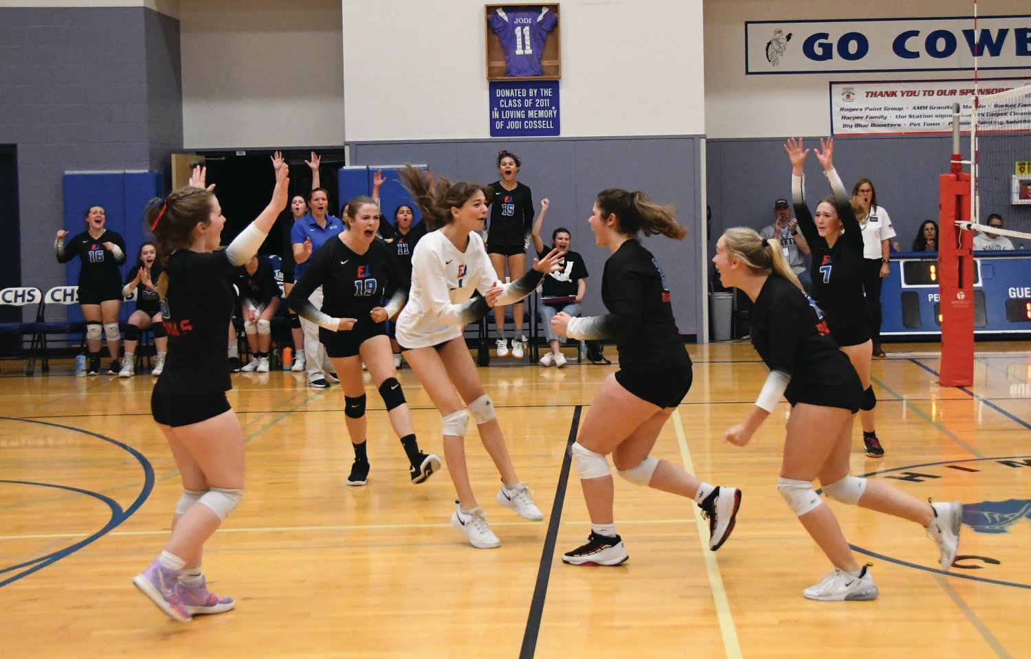 EJ’s varsity lineup celebrates after scoring a point during the second set of the matchup
