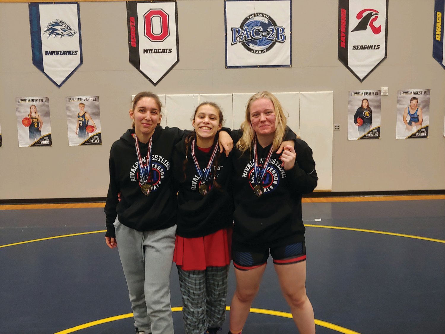 Chloe Lampert, Mi Amada Lanphear Ramirez, and Melody Douglas show their hard-earned medals achieved through a day of tough matches on the mat at the Forks wrestling tournament.