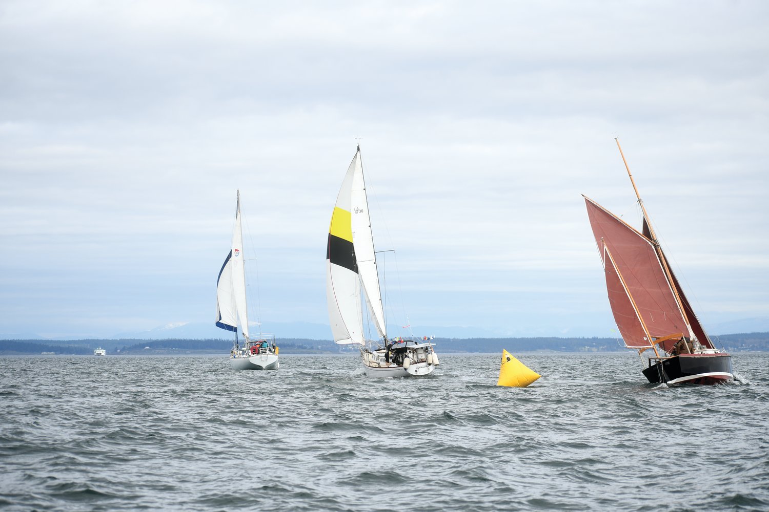 Sailboats move through one of the three buoy checkpoints in last year’s Shipwrights’ Regatta.