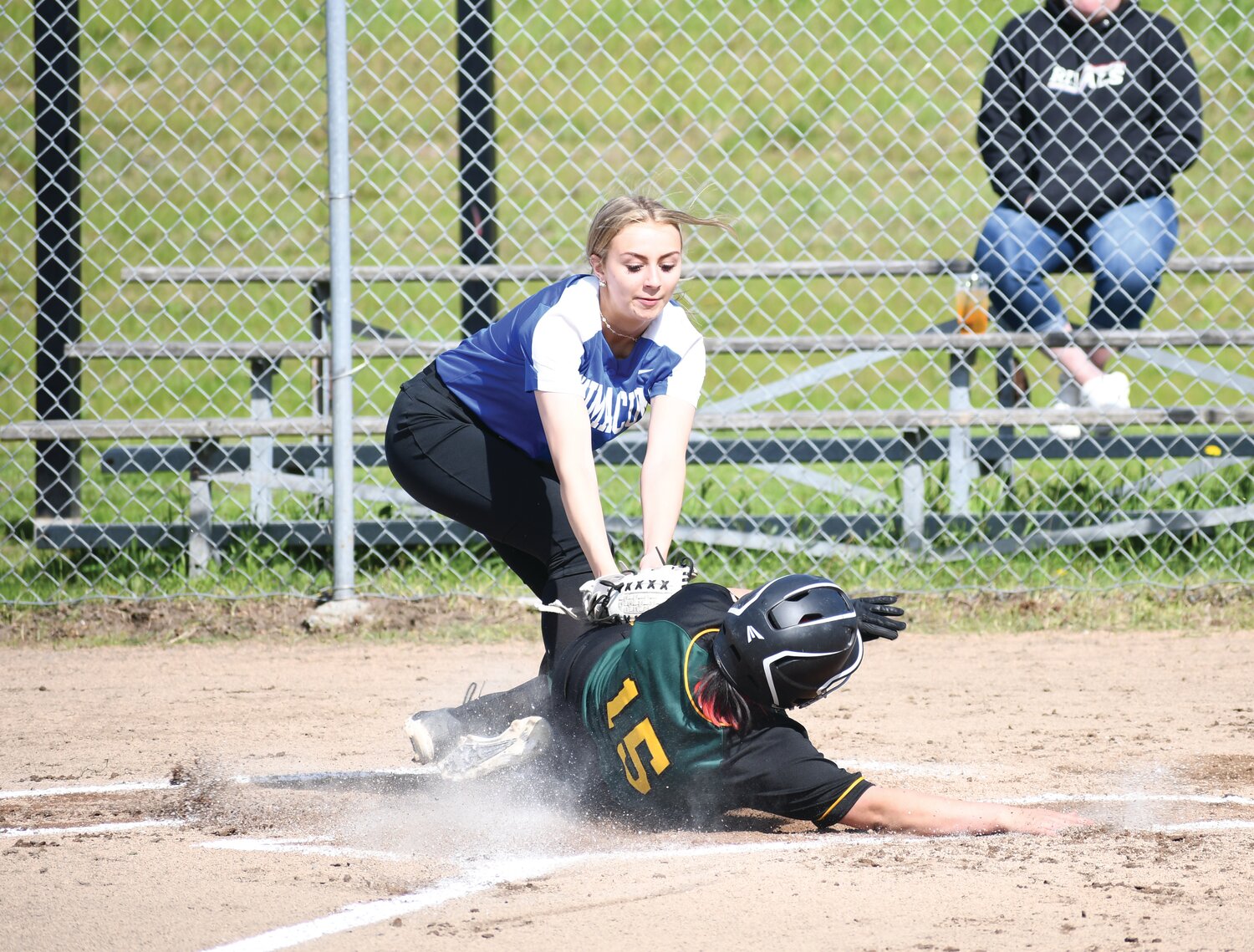 Senior pitcher Macy Aumock attempts to tag out a Pirate player sliding into home base.
